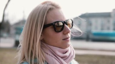 Thoughful çekici beyaz kız portresi. Oldukça yetişkin 30'lu yaşlarda saç uçan ile şık güneş gözlüklü sarışın kadın.