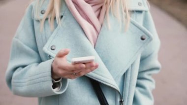 Ağır çekim genç beyaz Bayan Smartphone kullanarak. 20'li yaşlarda güzel sarışın video arama yapma uzun sarı saçlı. Yukarı eğimli.