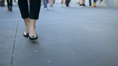 Genç kadın ile şehir merkezine yürüyüş yakın çekim görünüm. İşkadını topuklu siyah ayakkabı giyiyor. Ağır çekim.