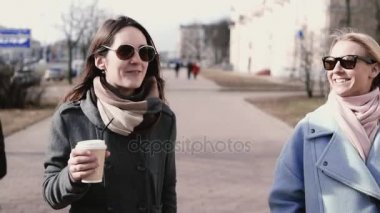 İki beyaz çekici kızlar beraber yürüyelim. Ağır çekim. Yetişkin bayan arkadaş chat yapan şık giyim güneş gözlüğü.
