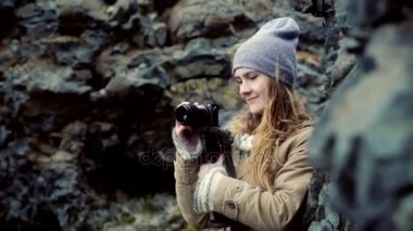 Dağlarda ayakta ve kamera üzerinde filme genç güzel kadın. Turist kadın alarak fotoğraf gezisi.
