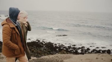 Genç bir çift deniz kıyısında birlikte yürüyüş. Romantik bir tarih suya yakın erkek ve kadın, beraber seyahat.