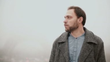 Şehir merkezinde, sisli sabah Paris, Fransa'da Eyfel Kulesinin yakınında duran ve etrafa düşünceli genç adam.