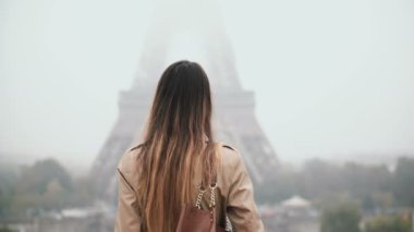 Şehir merkezinde yürüyüş ve cep telefonu üzerinde konuşurken genç güzel kadın. Erkek Paris, Fransa'da Eyfel Kulesinin yakınında.