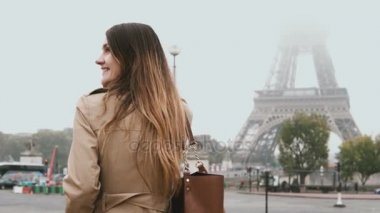 Fransa'nın Paris, Eyfel Kulesi yakınındaki sisli sabah yürüyüş ve cep telefonu üzerinde konuşurken genç güzel kadın.