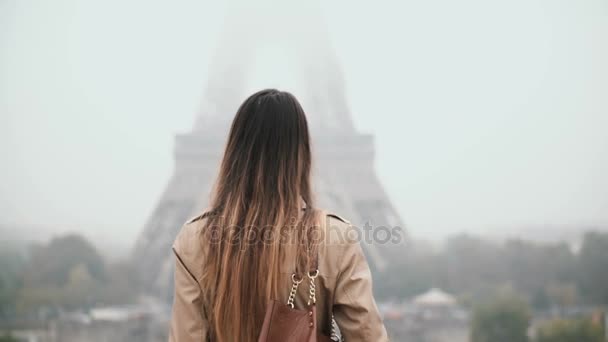 Junge schöne Frau, die in der Innenstadt spaziert und mit dem Handy telefoniert. Weibchen in der Nähe des Eiffelturms in Paris, Frankreich. — Stockvideo