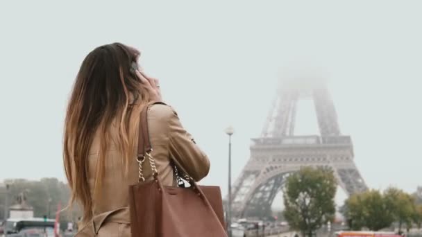 Młoda szczęśliwa kobieta spaceru w centrum Paryża i rozmowy na telefon komórkowy. Uśmiecha się kobieta, w pobliżu wieży Eiffla — Wideo stockowe
