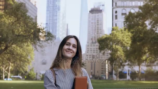 Portret młodej kobiety uśmiechający się w Nowym Jorku, Usa. Piękna kobieta interesu dokumenty i patrząc na kamery. — Wideo stockowe
