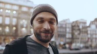 güzel bir şehir manzarayı 4 k düşünceli bir adam. Etrafa. Atış kaydırma kapatın. Heyecanlı gülümseyen adam mutlu yürür.