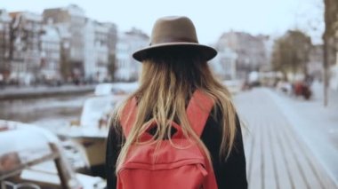 Avrupa kadın turist ile telefon Nehri yakınında yürür. Güzel Gezgin erkek bir nehir rıhtım yürüyüş etrafında görünüyor. 4k.