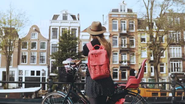 Menina com bicicleta enviando vídeo para amigos on-line. Bela mulher europeia blogando em redes sociais. Vista traseira. 4K — Vídeo de Stock