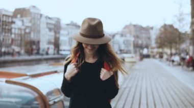 Avrupa kadın turist portresi nehir kenarında yürüyüş. Mutlu traveler düşünceli erkek bir setin etrafına bakıyor. 4k.