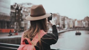 Genç kız fotoğrafları ve telefon görüşmeleri alır. Uzun saçlı, kırmızı sırt çantası çalışma güzel kadın gazeteci. 4k.
