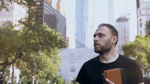 Portré, fiatal, boldog üzletember állt a park közelében, a hivatalok és felhőkarcolók, New York, Amerikai. — Stock videók