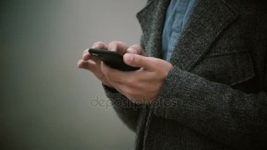 Yakın çekim görünümünü cep telefonu sisli sabah holding erkek eller. Dokunmatik ekranlı akıllı telefon kullanan şık adam.