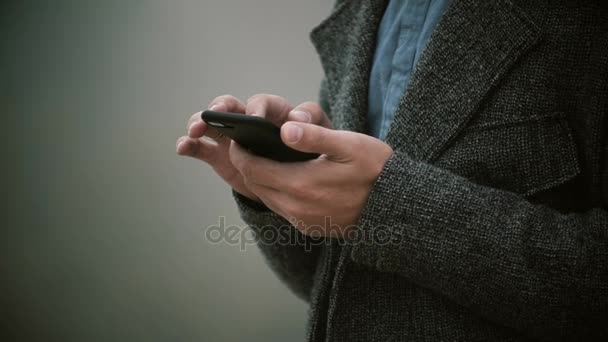 Vista de cerca de las manos masculinas sosteniendo el teléfono móvil en la mañana brumosa. Elegante hombre con teléfono inteligente con pantalla táctil . — Vídeos de Stock