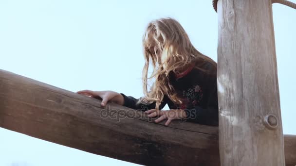 Portrait of 5 year old cute girl on playground. Cute happy smiling kid with long hair goes over ropes course obstacles. — Stock Video