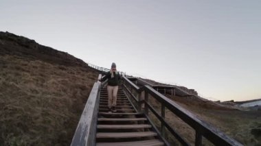 Genç güzel kadın merdivenlerden iniyor. Aptal surat ve onu izlemeye davet mutlu erkek.