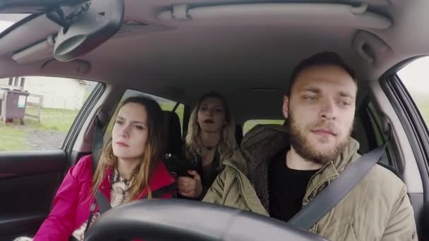Glada ungdomar som reser med bil tillsammans. Vänner försöker att hitta vägen, man kör fordonet. — Stockvideo
