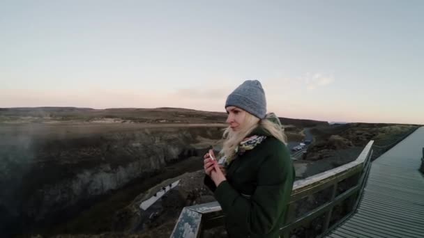 Ung glad kvinde står på broen og nyder det smukke landskab. Turist kvindelige bruger tid på naturen . – Stock-video