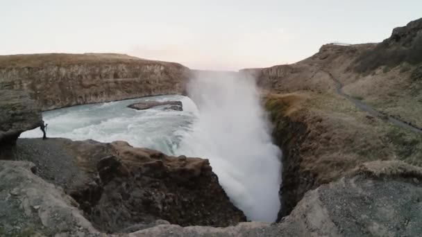 Jeune touriste prenant des photos de la belle cascade de Gullfoss en Islande. Voyager mâle explorer le nouvel endroit . — Video