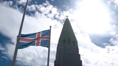 Güzel güzel kilise Reykjavik, İzlanda ve ulusal bayrak sallayarak rüzgarla tanımlıkHallgrimskirkja görünümünü.