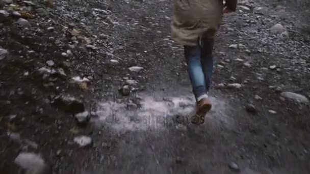 Close-up view of anxious male foot in boots running away from somebody through the rocky way in Iceland. — Stock Video