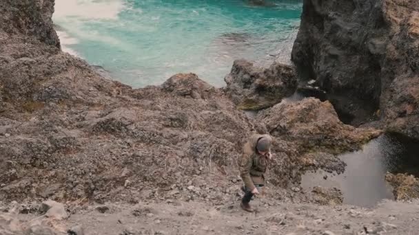 Young handsome man hiking alone. Traveling male walking, climbing through the hill near the blue lake alone. — Stock Video