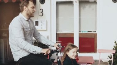 Kargo bisiklet üzerinde iki mutlu çocuk ile gülümseyen adam. Ağır çekim yan görünüm. Bekar baba aile bağlar zaman. Tek üst.