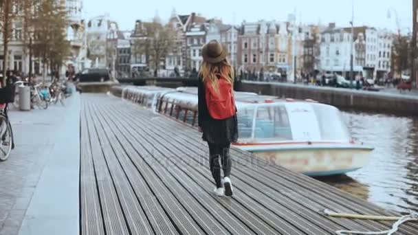 Leuke toeristische vrouwelijke wandelingen, gesprekken over de telefoon. Gelukkig ontspannen reiziger wandelen langs de rivier boot embankment. 4k terug bekijken. — Stockvideo