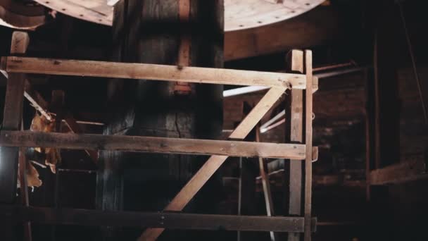 4 k hagyományos mill mechanizmus dolgozik közelről. Hatalmas, régi, fából készült holland szélmalom core spinning belül. Ősi technológia. — Stock videók
