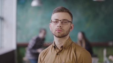 Meşgul ofis genç ciddi işadamı portresi. Kameraya bakarak yakışıklı erkek çalışan