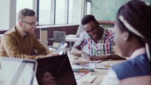 Creative business team meeting in modern office. Mixed race group of young people discussing start-up ideas, laughing. — Stock Video