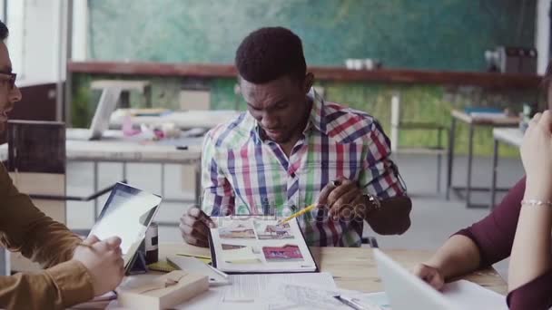 Équipe créative d'architectes réunis dans un bureau moderne. Groupe mixte de jeunes discutant d'idées de start-up .