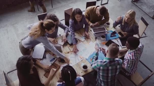 Geschäftstreffen im modernen Büro. Draufsicht auf eine multiethnische Gruppe von Menschen, die in der Nähe des Tisches zusammen arbeiten. Langsames Wachstum — Stockvideo