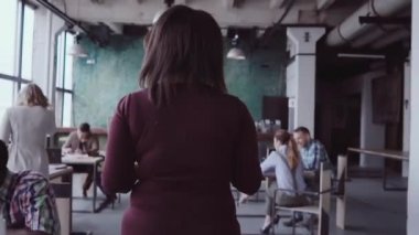 Modern ofis ve denetimleri bir çalışmayla çalışanın yürüyen genç Afrika takım lideri. Erkek kumaş örnekleri görünüyor.