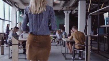 Kadın Yöneticisi iş ekibine geliyor. Karışık yarış grup ofiste toplantı insan. Kamera legs--dan yukarı taşır. yavaş mo