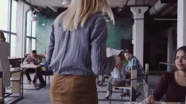 Çalışanın ofis ve denetimleri çalışma sayesinde yürüyen kadın sarışın takım lideri. Erkek kumaş örnekleri yavaş mo görünüyor