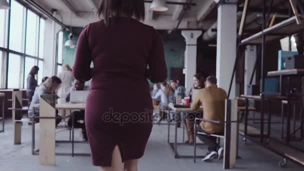 Jeune chef d'équipe africaine marchant à travers le bureau et contrôle le travail de l'employé. Femme regarde les exemples de tissu ralenti mo — Video