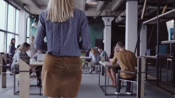 Vrouwelijke manager komt aan zakelijke team. Gemengd ras groep mensen bijeen in office. Camera gaat van de benen omhoog. slow mo — Stockvideo