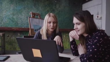 İki genç iş kadın sarışın ve esmer toplantı modern Office Başlangıç fikirleri tartışmak