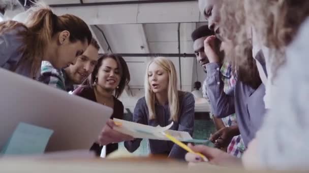 Young team working on new project. Group of mixed race people standing near the table and discussing. — Stock Video