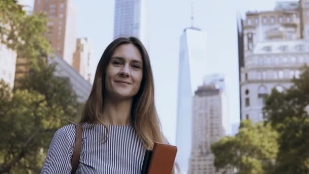 Portret młodego bizneswoman gospodarstwa dokumenty. Kobiece patrząc na kamery i daje kciuki up w New York, Stany Zjednoczone Ameryki — Wideo stockowe