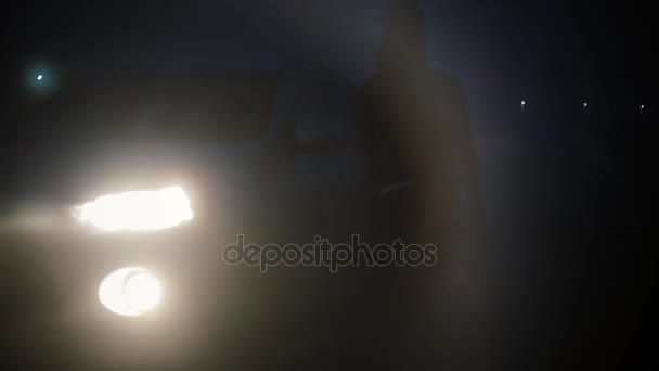 Pandangan abstrak. Perempuan masuk ke mobil di malam hari. Blurry gelap kabut bokeh latar belakang jalan raya ditembak petualangan misterius . — Stok Video
