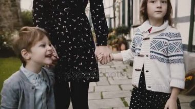İki Avrupa çocuk annesi ile birlikte elele tutuşun. Sakin ve ciddi erkek ve kız anne yakın dur. Yaşam tarzı 4 k vurdu.