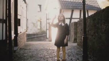 Çok Avrupa kız hava öpücük atar, kaçıyor. Poz, kameradan döşeli yolda çalışan kadın çocuk heyecanlı. 4k.