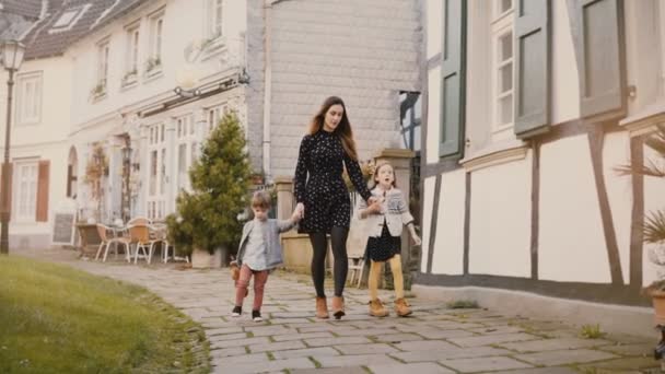 Hezká žena chodí s dvěma dětmi, drželi se za ruce. Kavkazská matka, chlapec a dívka putování. Rodinné vztahy. 4k. — Stock video