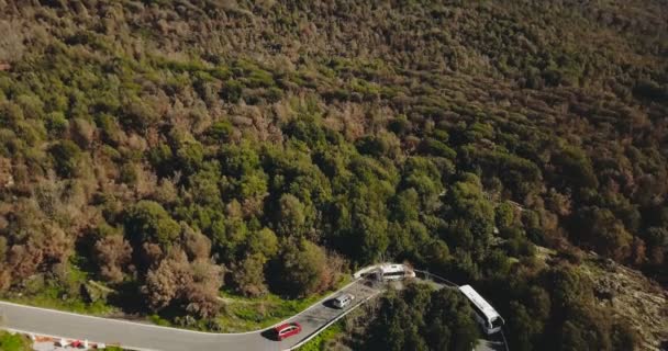 Drone se nakloní dolů na horské silnici a vozidel. Letecký pohled na úžasnou letní hadec s autobusem, van a dvě auta. 4k. — Stock video
