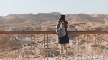 Kadın sırt çantası ile büyük mountain view adlı görünüyor. Çok beyaz kız inanılmaz çöl panorama hoşlanır. İsrail 4k.