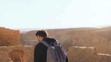 Erkek turist inanılmaz dağ manzarası fotoğrafları. Genç adam sırt çantası ile fotoğraf çeker. Özgürlük. Masada İsrail 4k.